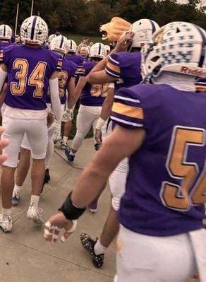 Lions football players in purple and gold uniforms on Come Home, Men of Latin night